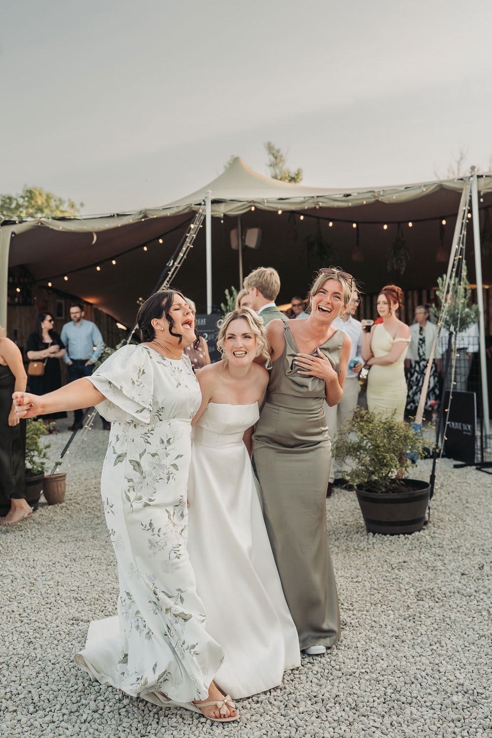 Bride hugging and laughing with friends at a Church Farm Brewery wedding by The Corbett Creative Photography