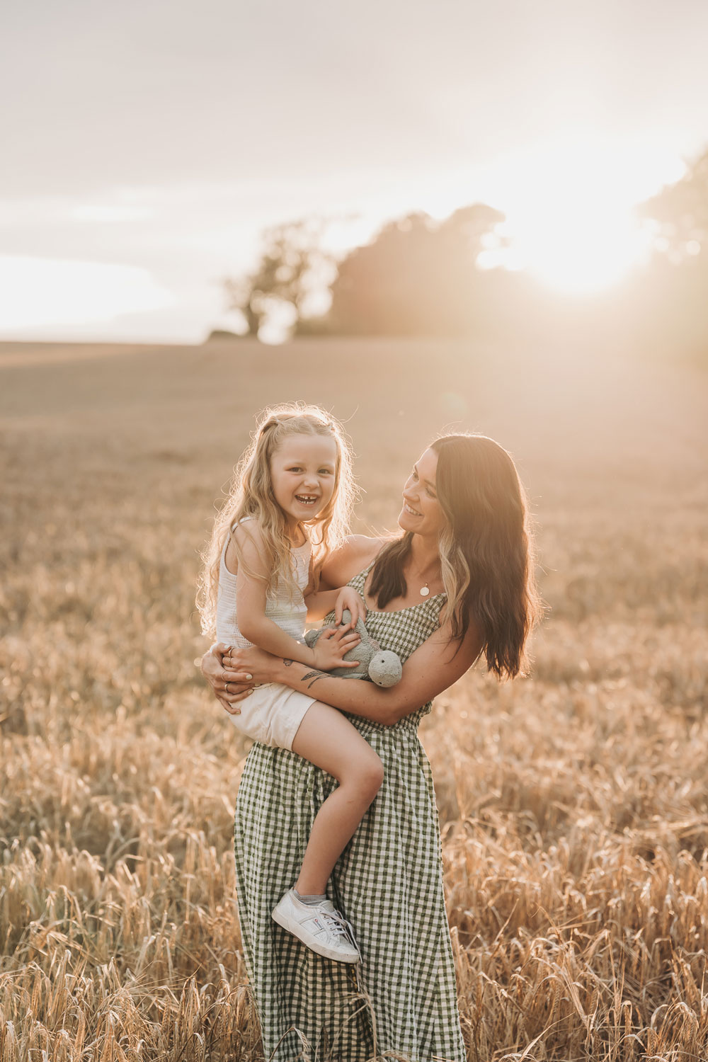 Golden hour portrait of family in crop field in Warwickshire