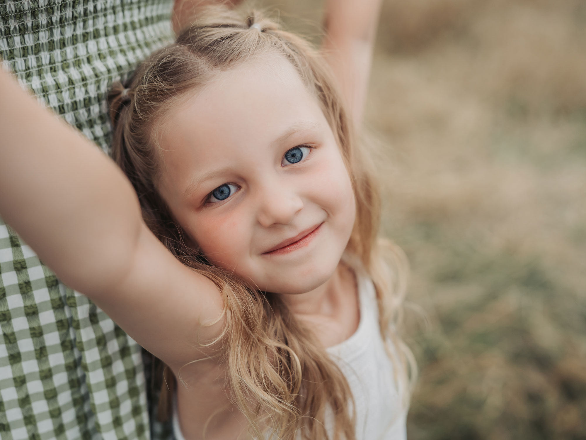 Close up portrait of blue-eyed girl during family photoshoot in Rugby, Warwickshire
