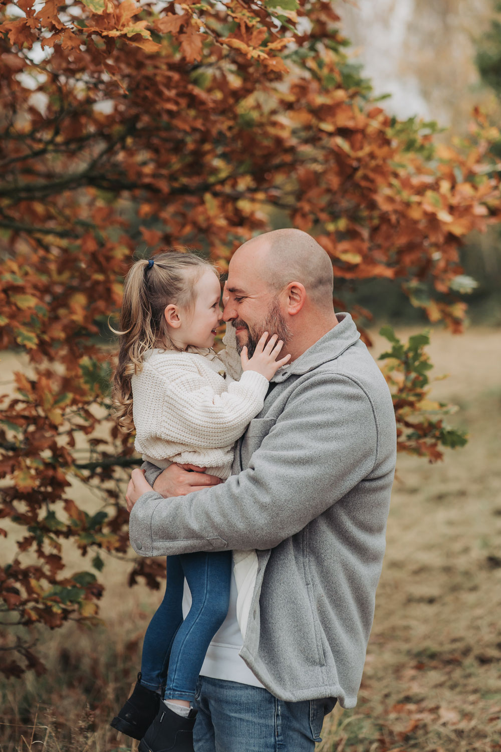 Warwickshire outdoor autumn family photoshoot with girl cuddling daddy's face