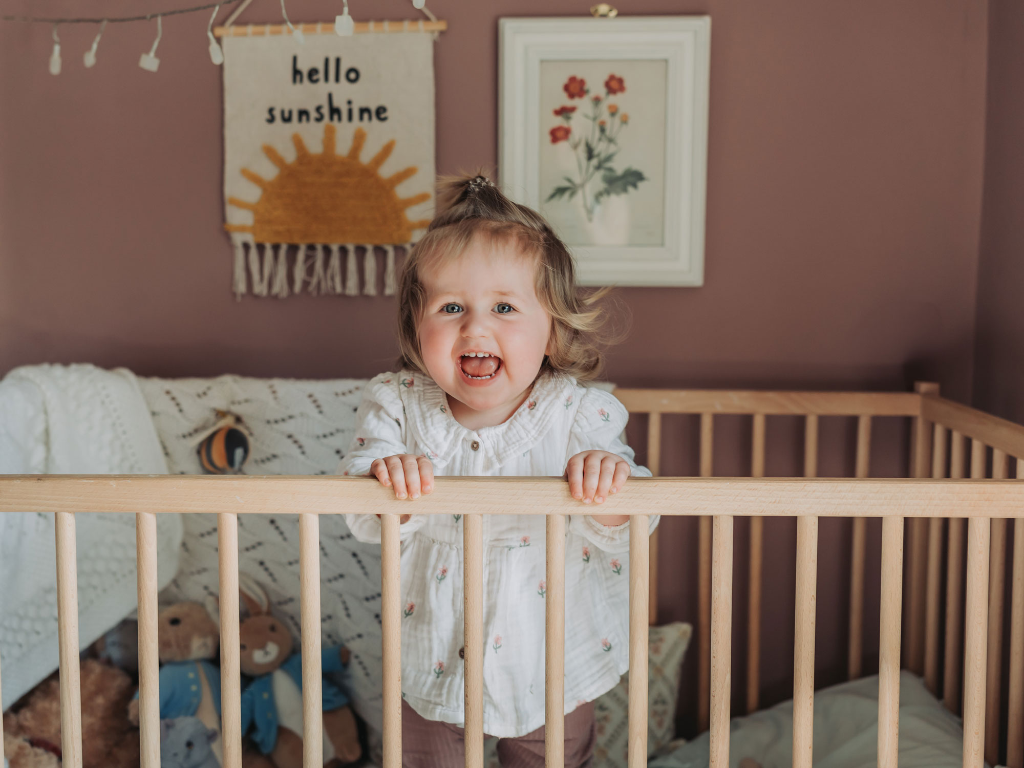 Leicestershire in home family photoshoot with toddler girl standing up in cot