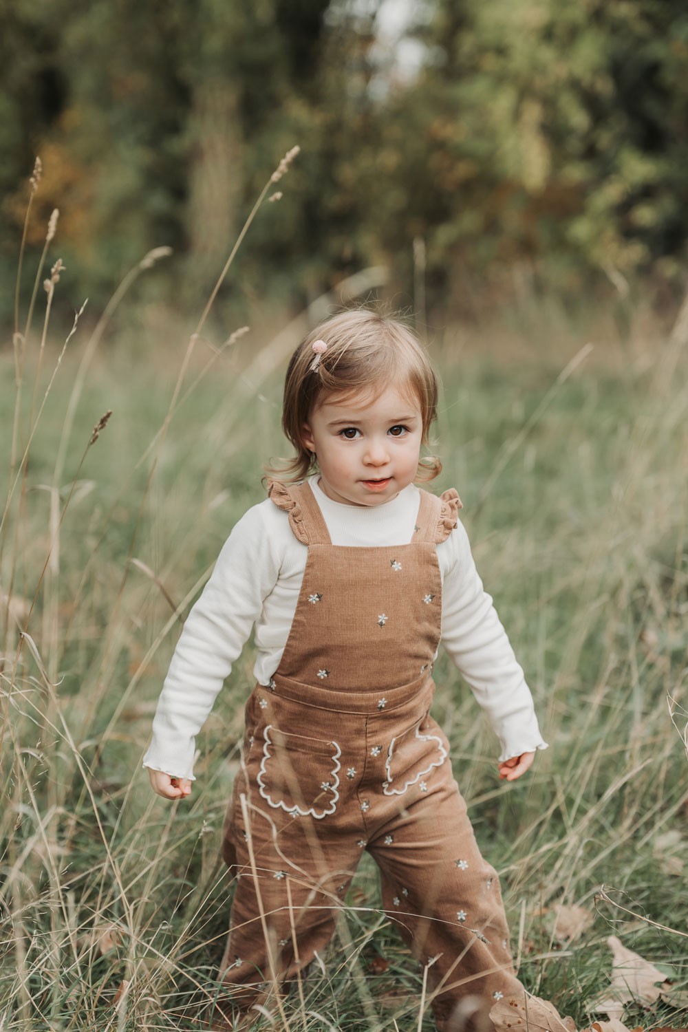 Stratford-Upon-Avon outdoor autumn family photoshoot with toddler girl in cord dungarees smiling at the camera