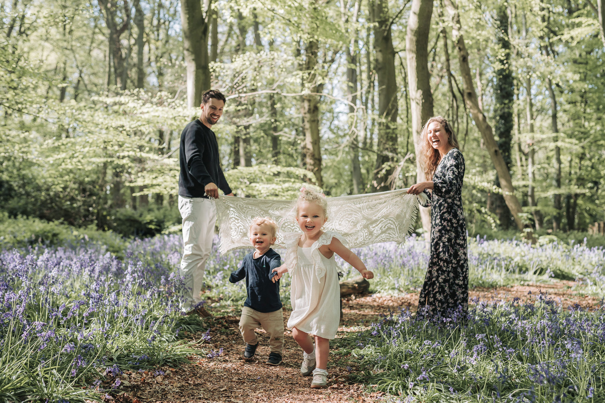 Warwickshire outdoor bluebell family photoshoot with children running towards camera smiling