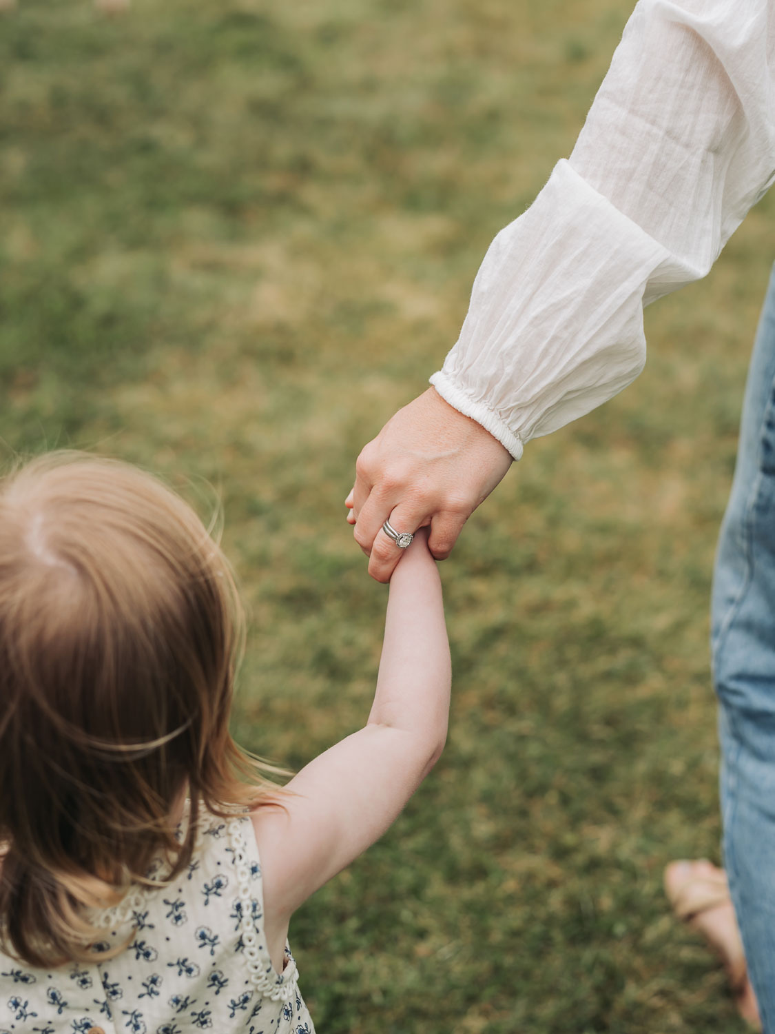 Warwickshire crop field photoshoot with close up photo of mum holding toddlers hand