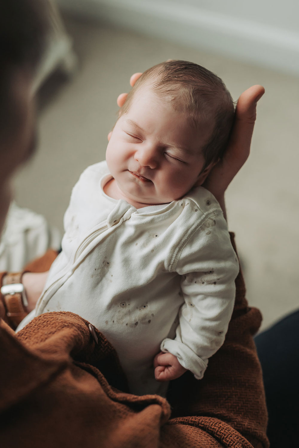 close up of baby asleep in dads hand