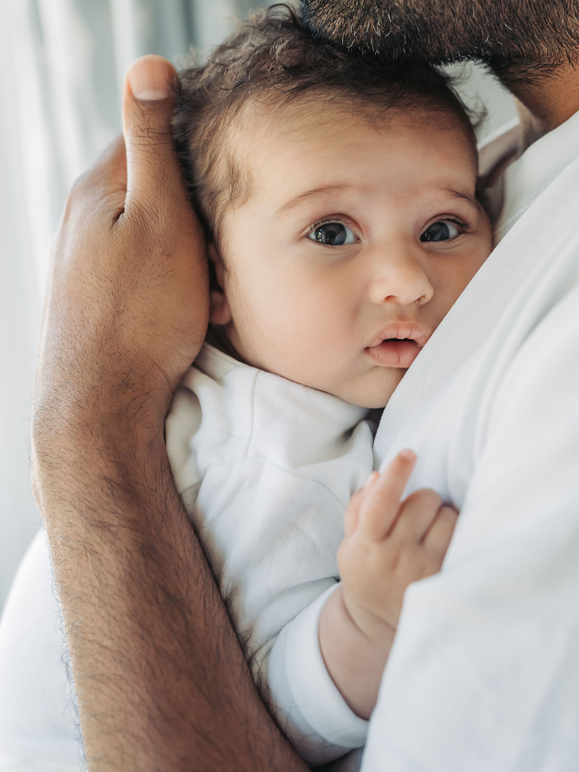 close up of baby's face whilst being held