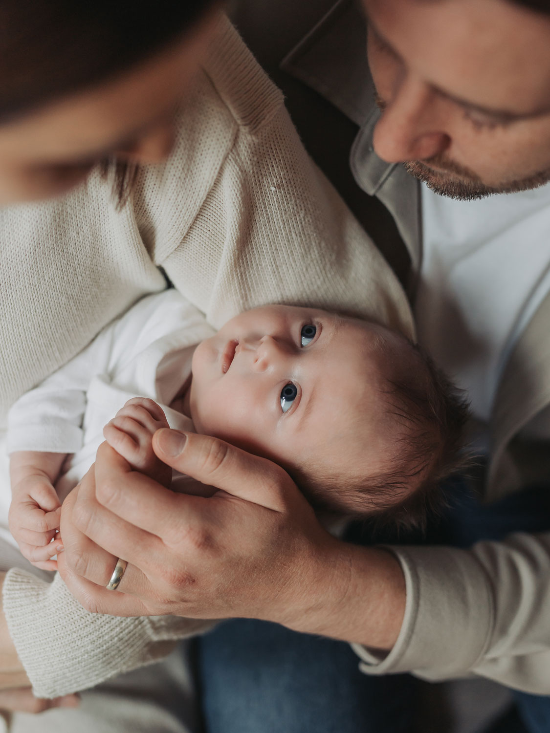 Baby looking up at mum and dad during an in home newborn shoot in coventry