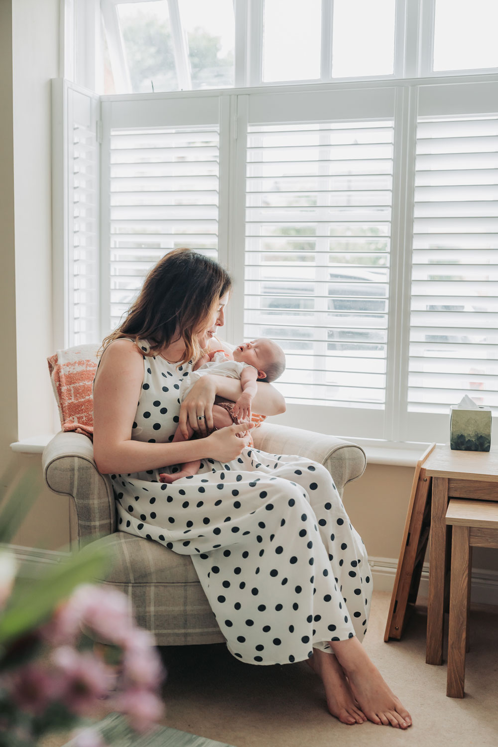 Mum sat in window holding her baby
