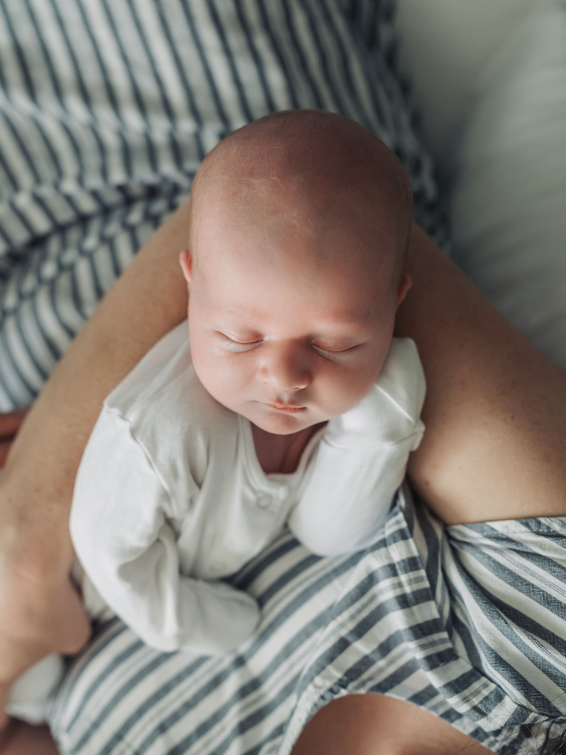 photo looking down at baby asleep in mums arms by the corbett creative photography
