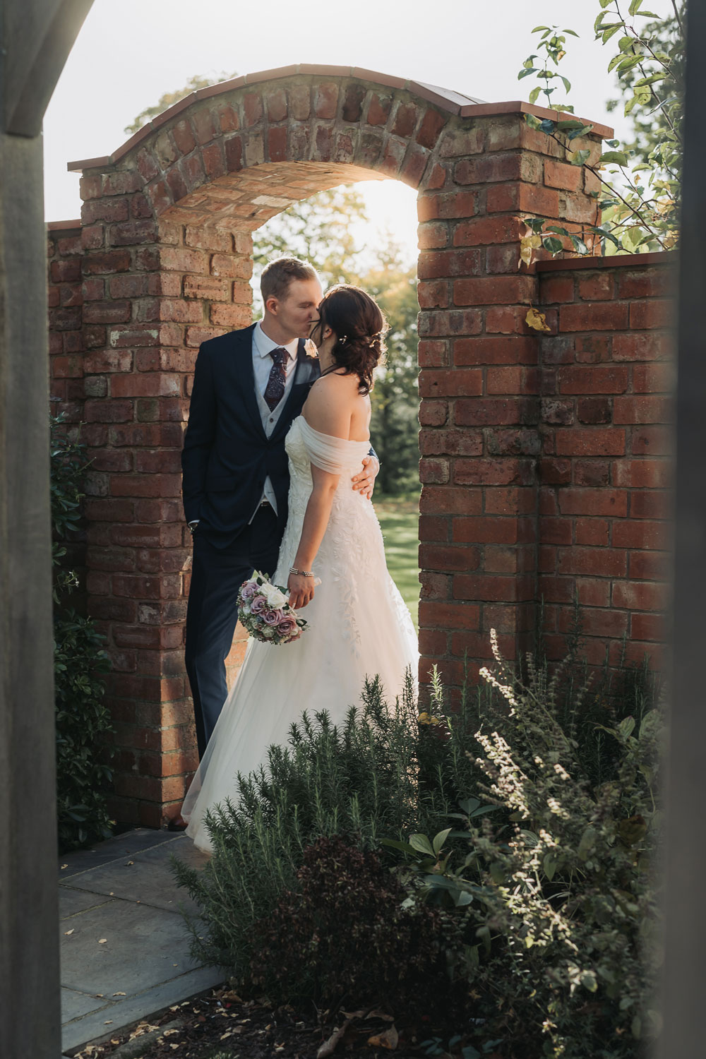 Golden hour couple portrait in archway at Ashton Lodge wedding venue Warwickshire