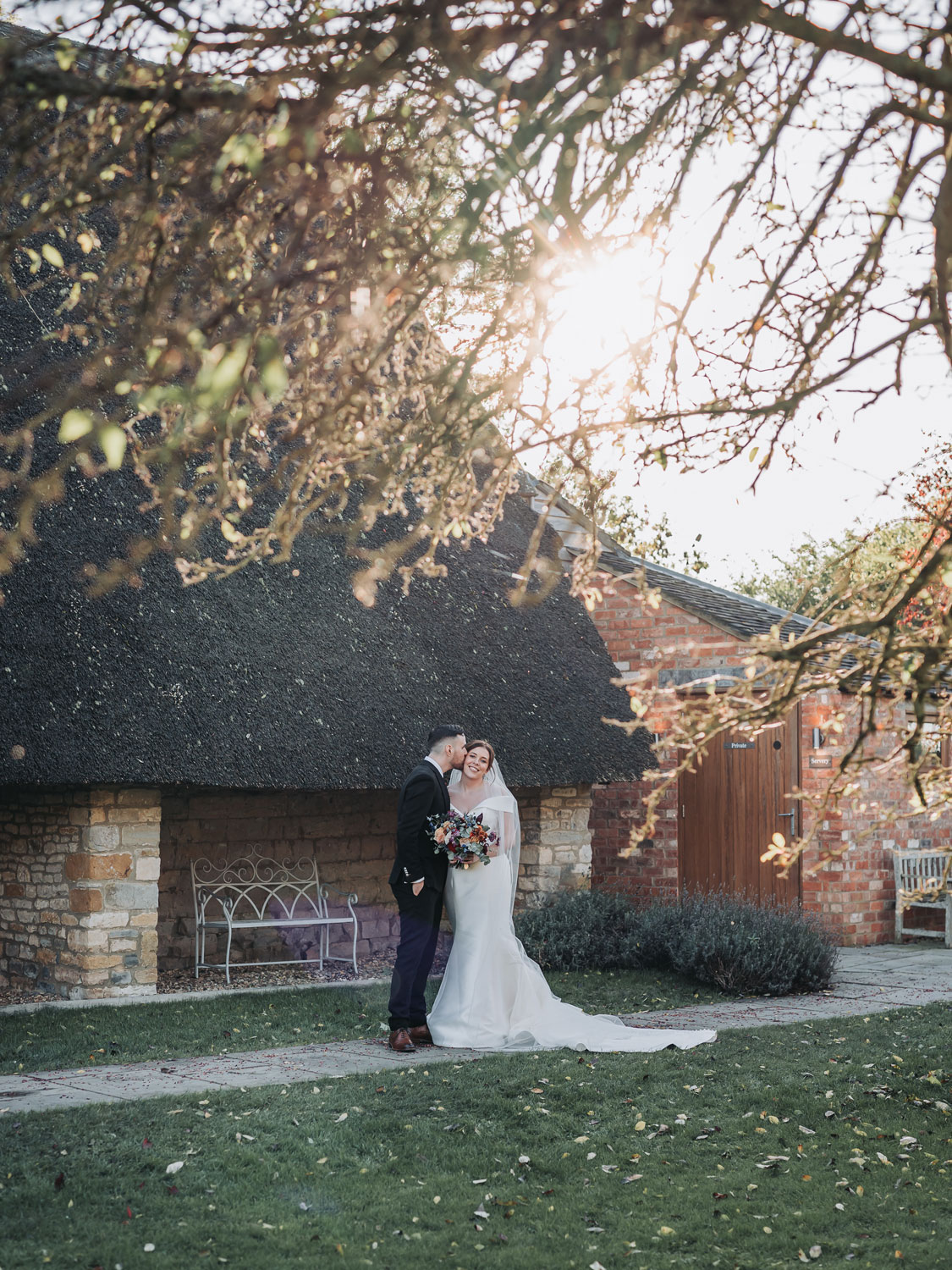 Couple portrait outside thatched barn at autumn Blackwell Grange wedding