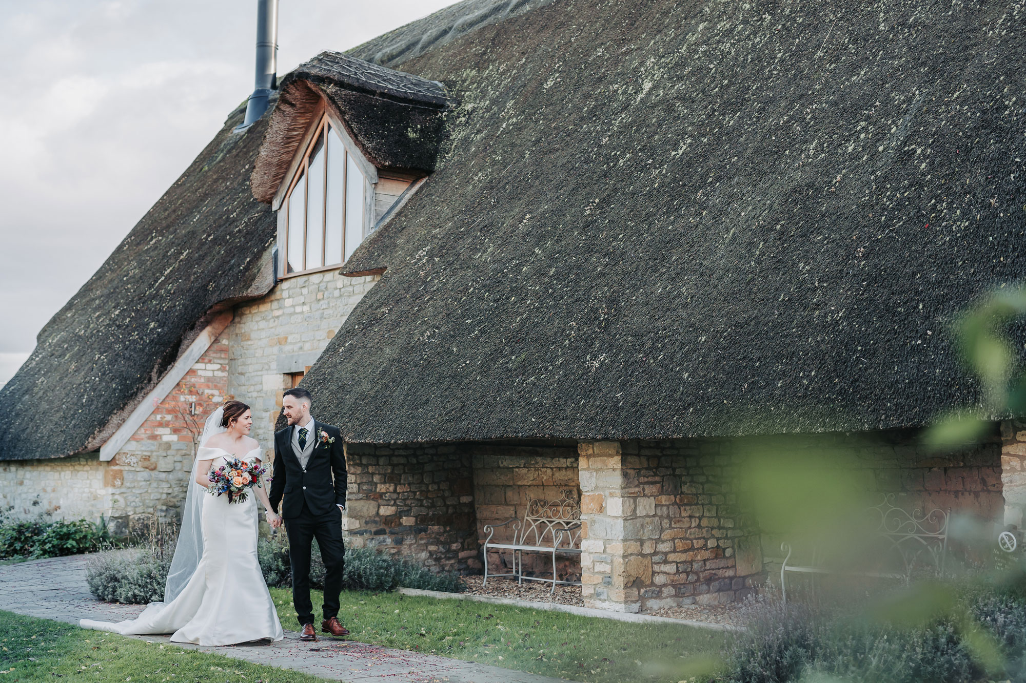 couple portrait walking outside Blackwell Grange thatched barn
