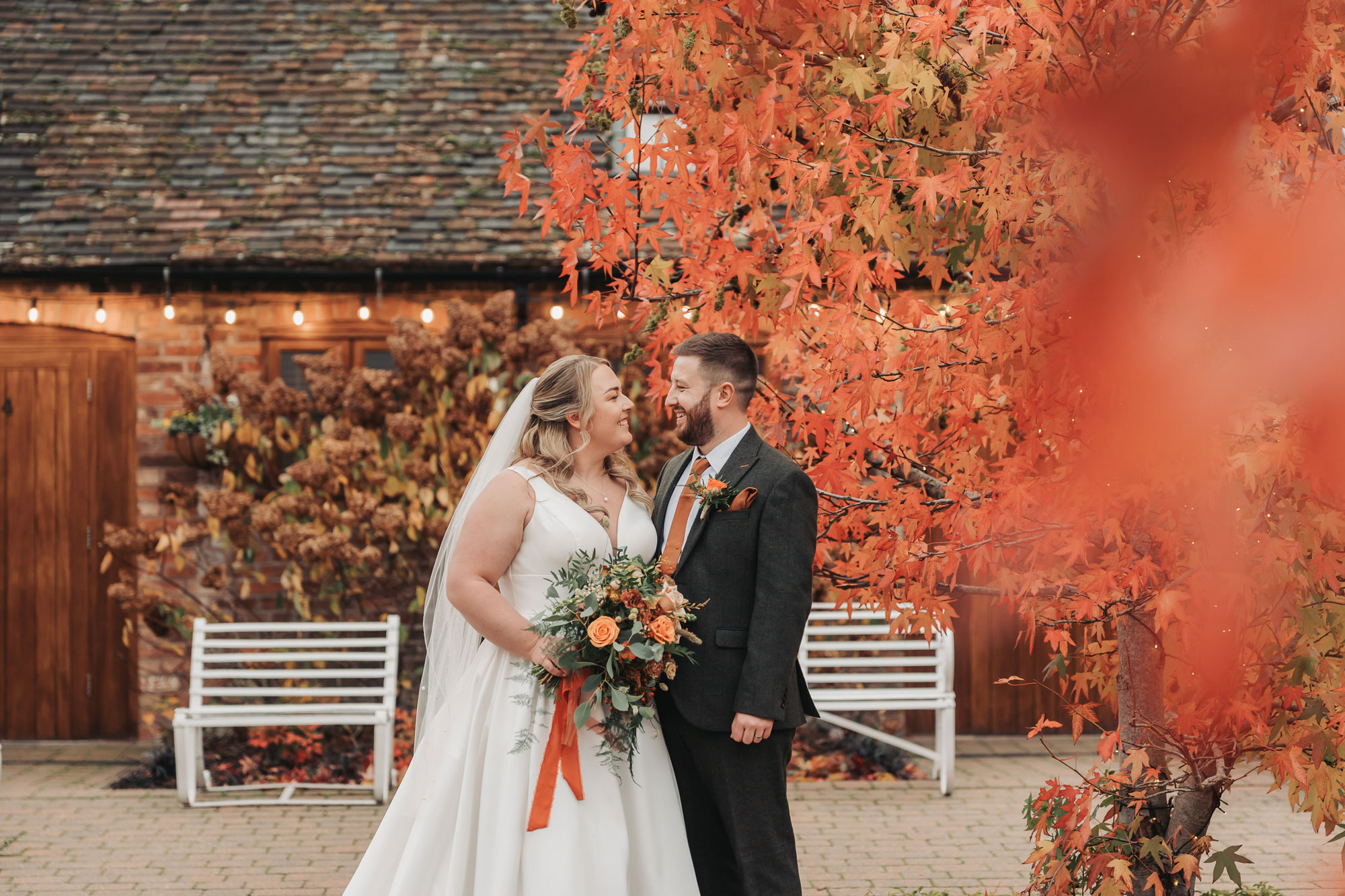 Mythe barn autumn wedding couple portrait with orange leaves