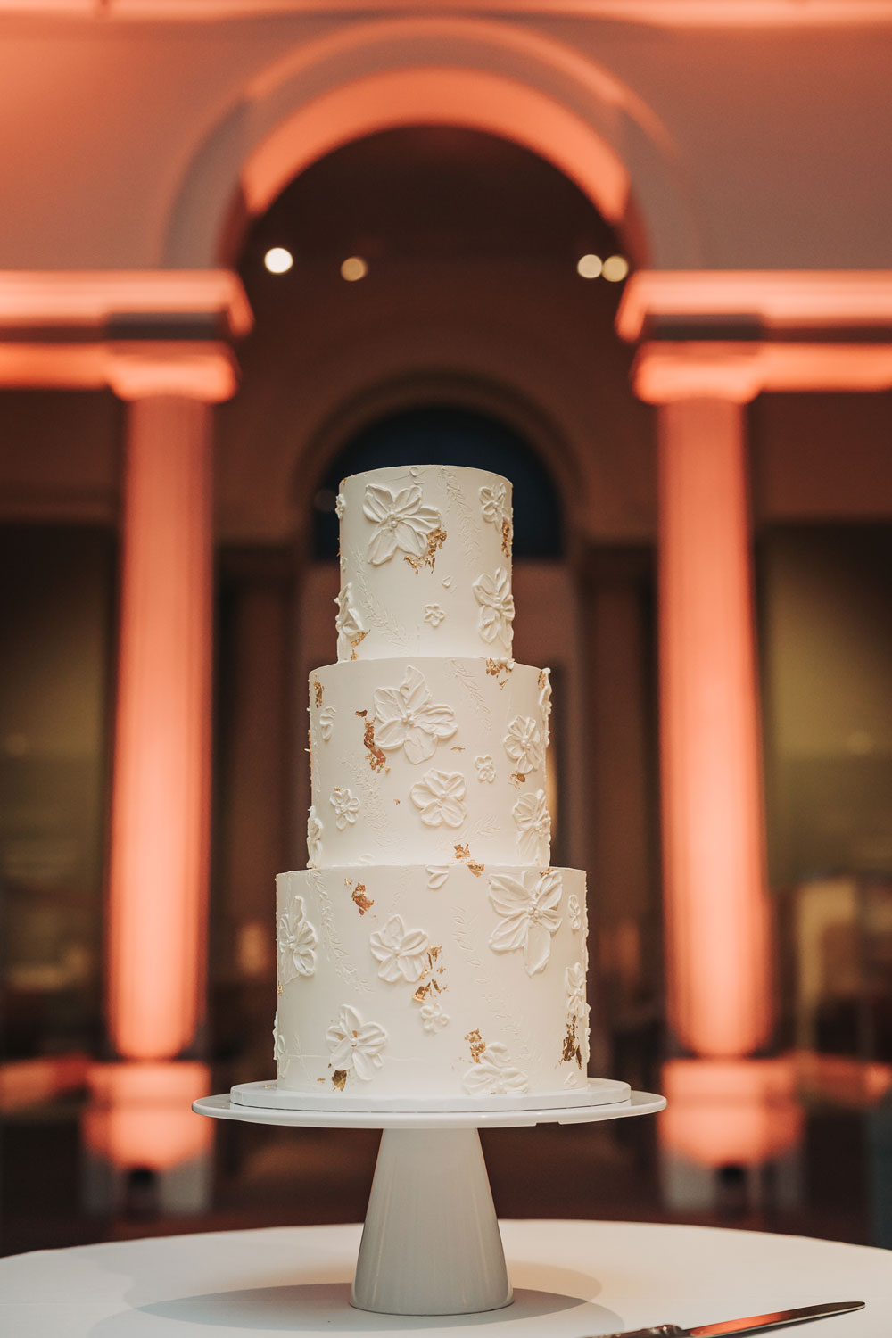 Three tier wedding cake with gold foil and flower detail