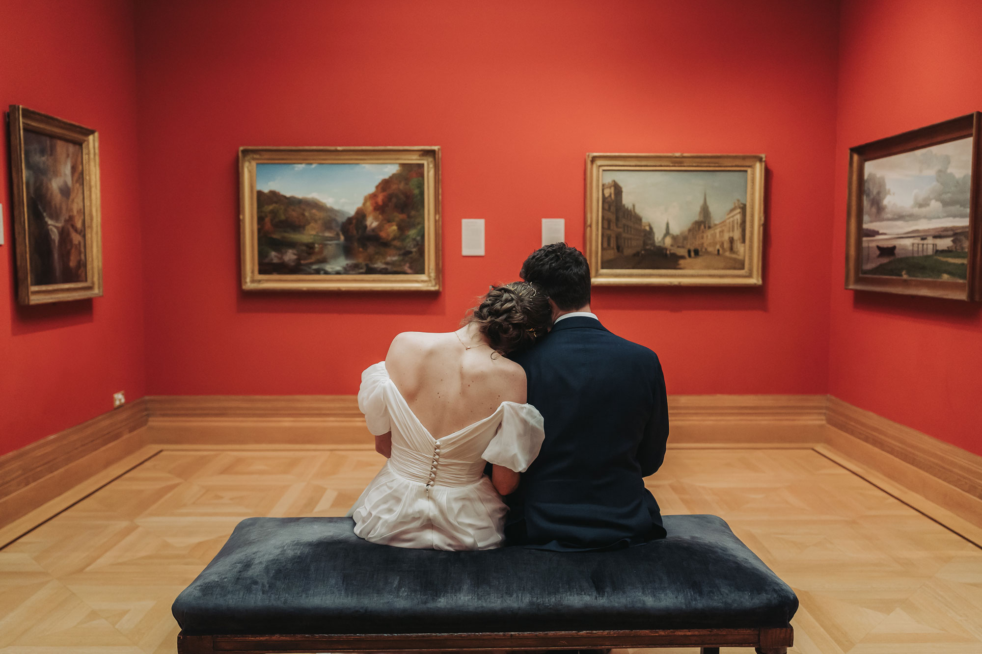 Bride leaning on groom's shoulder in art gallery at Ashmolean wedding