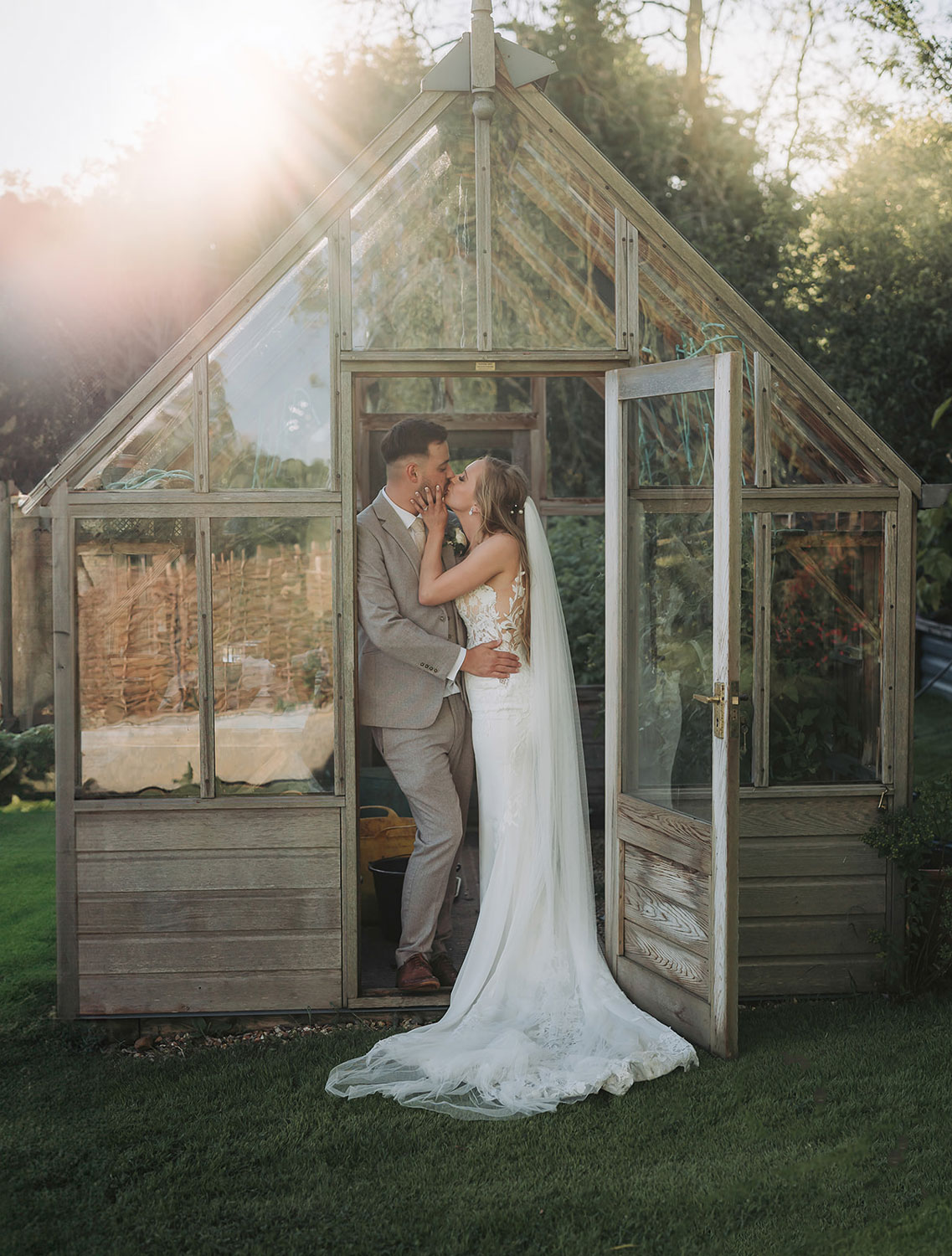 Bride and groom kissing in greenhouse at Crockwell Farm wedding venue