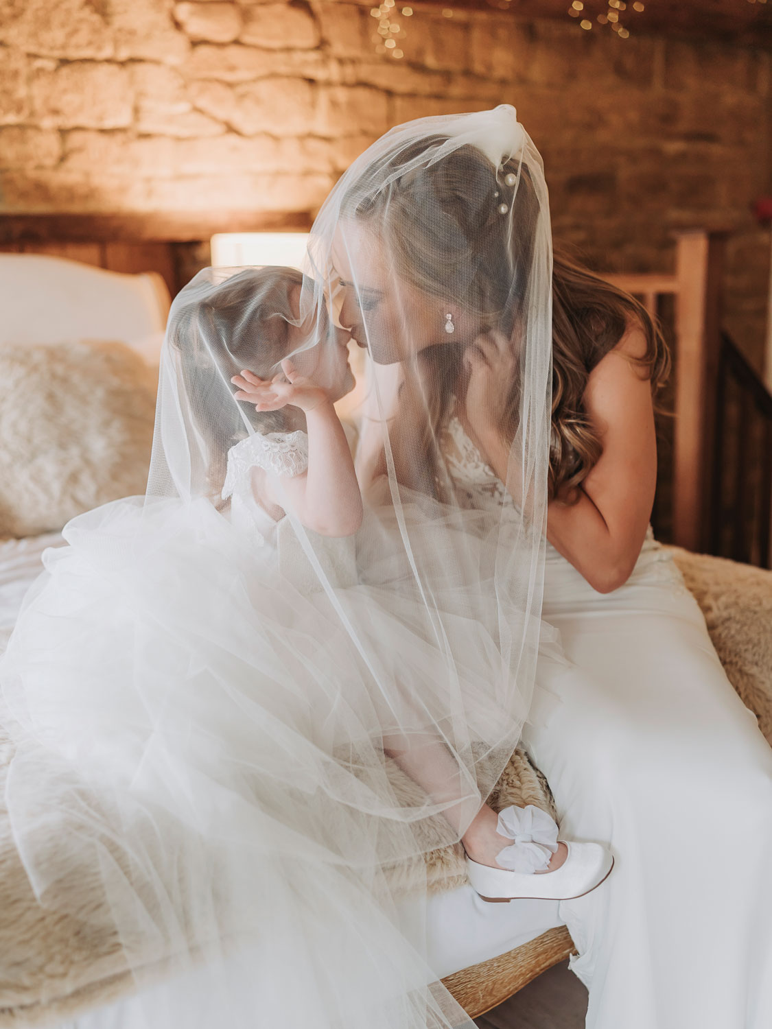 Bride kissing daughter under veil at Crockwell Farm wedding