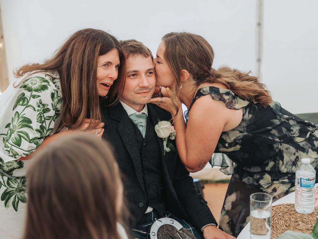 man being kissed on cheek