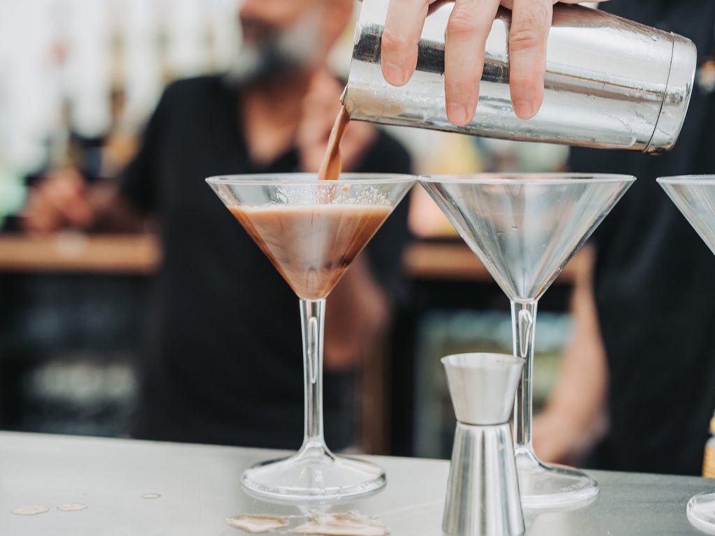 Close-up of espresso martini being poured into a cocktail glass