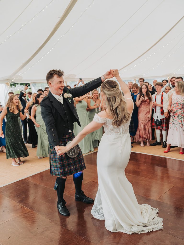 Bride and groom holding hands and dancing at wedding at Sherbourne Park