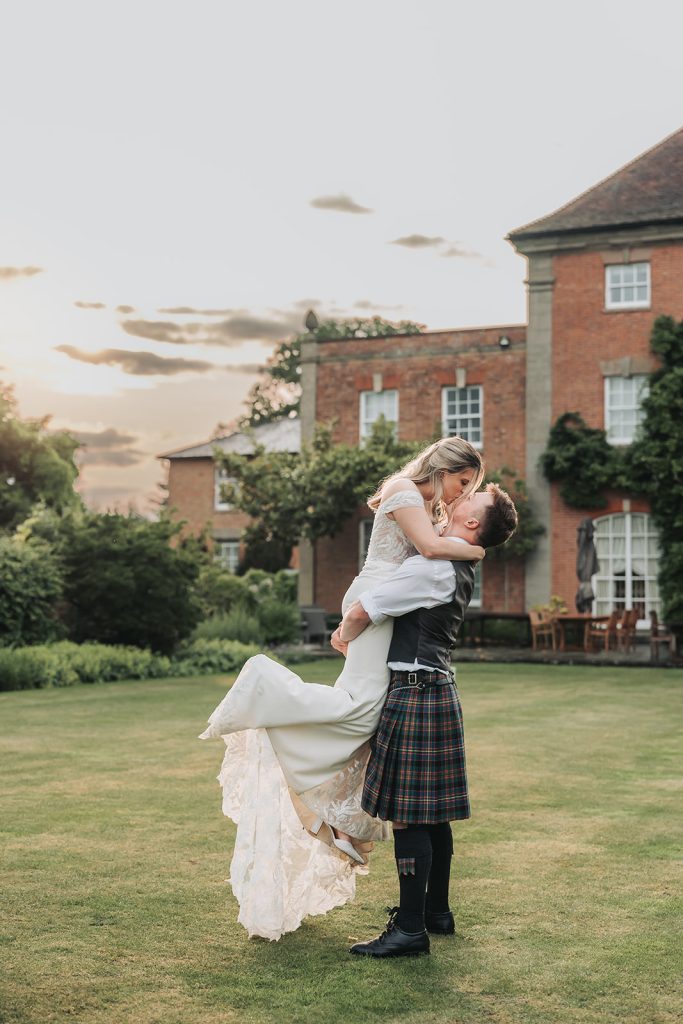 Groom lifting bride up and kissing at Sherbourne Park wedding venue