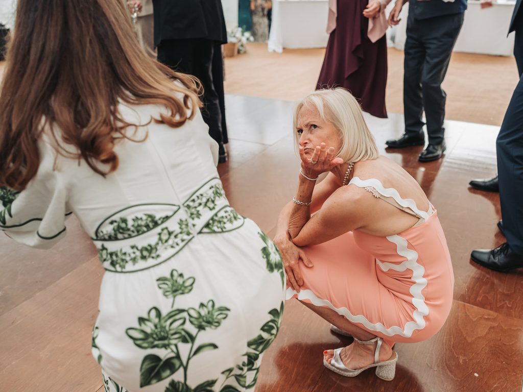 Wedding guest squatting on dance floor