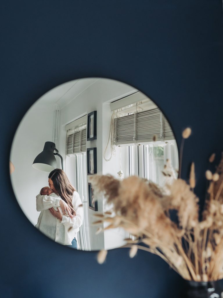 Mum kissing baby in mirror reflection