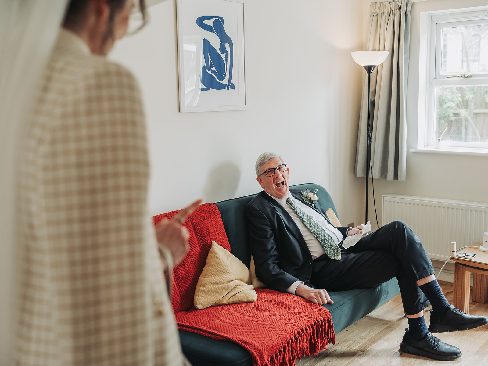 Father of bride looking happy sat on sofa