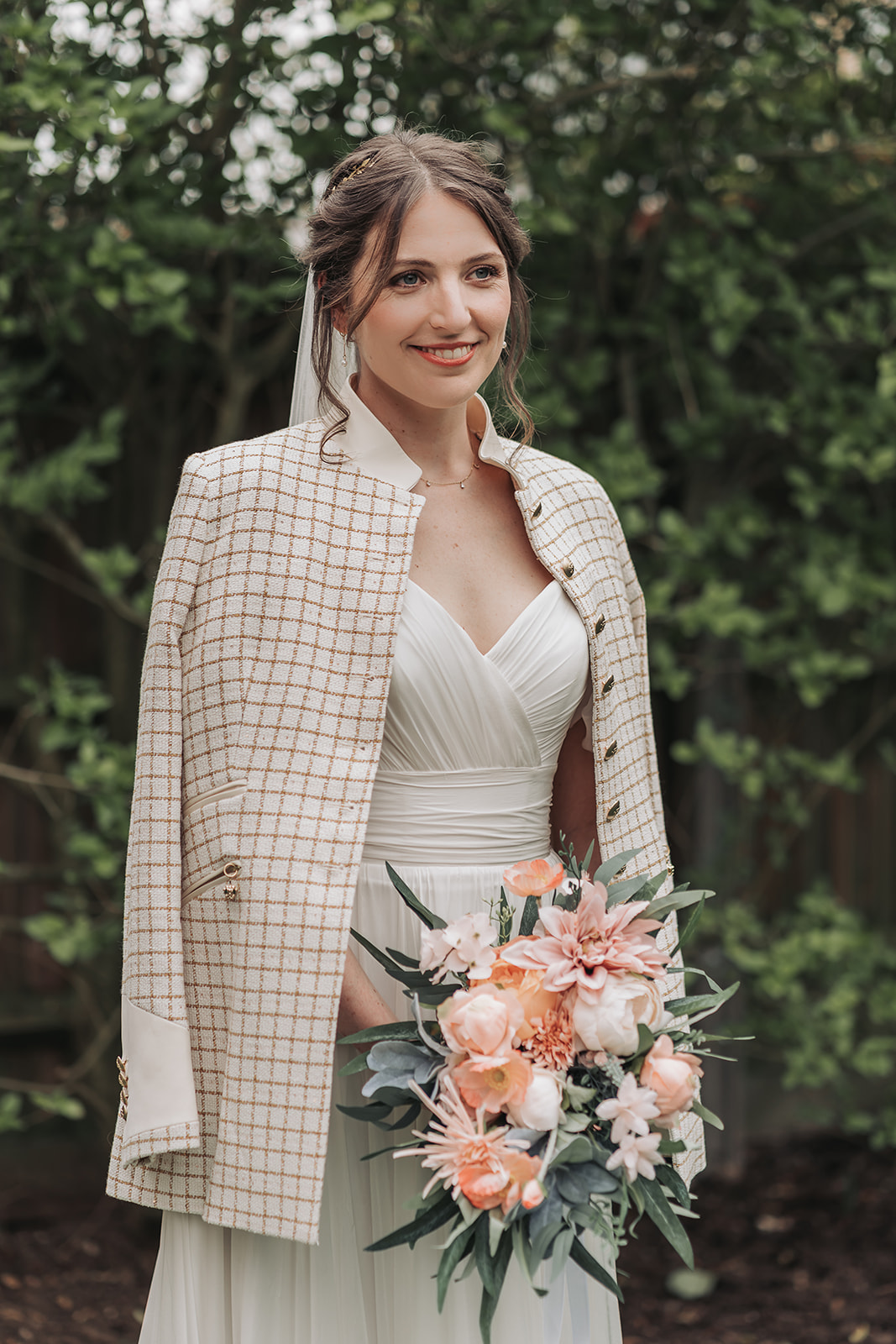 Bride wearing checked tweed jacket over her shoulders