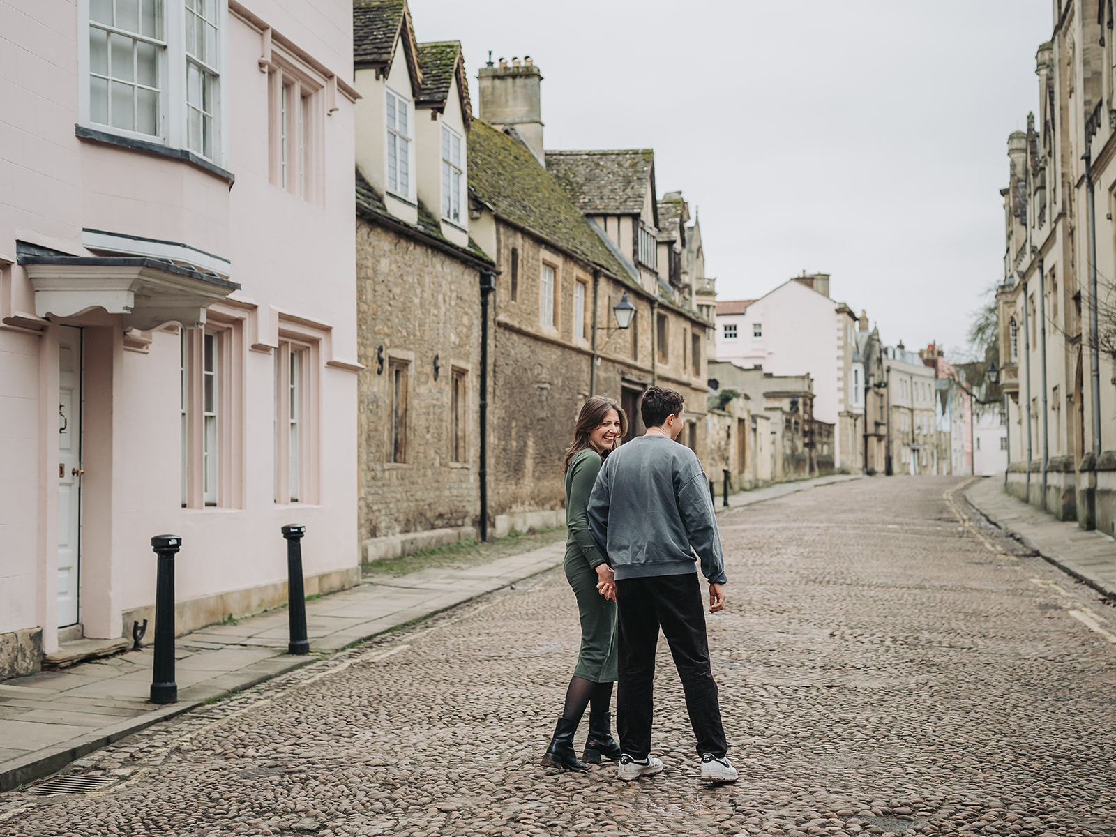 Couple walking cobbled streets of Oxford for engagement photoshoot