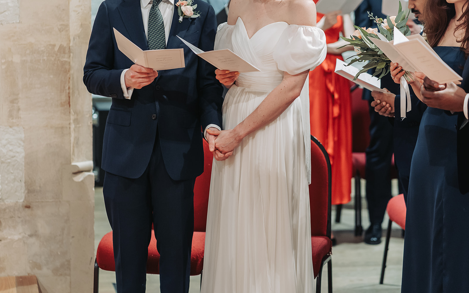 Bride and groom holding hands at St Ebbe's church