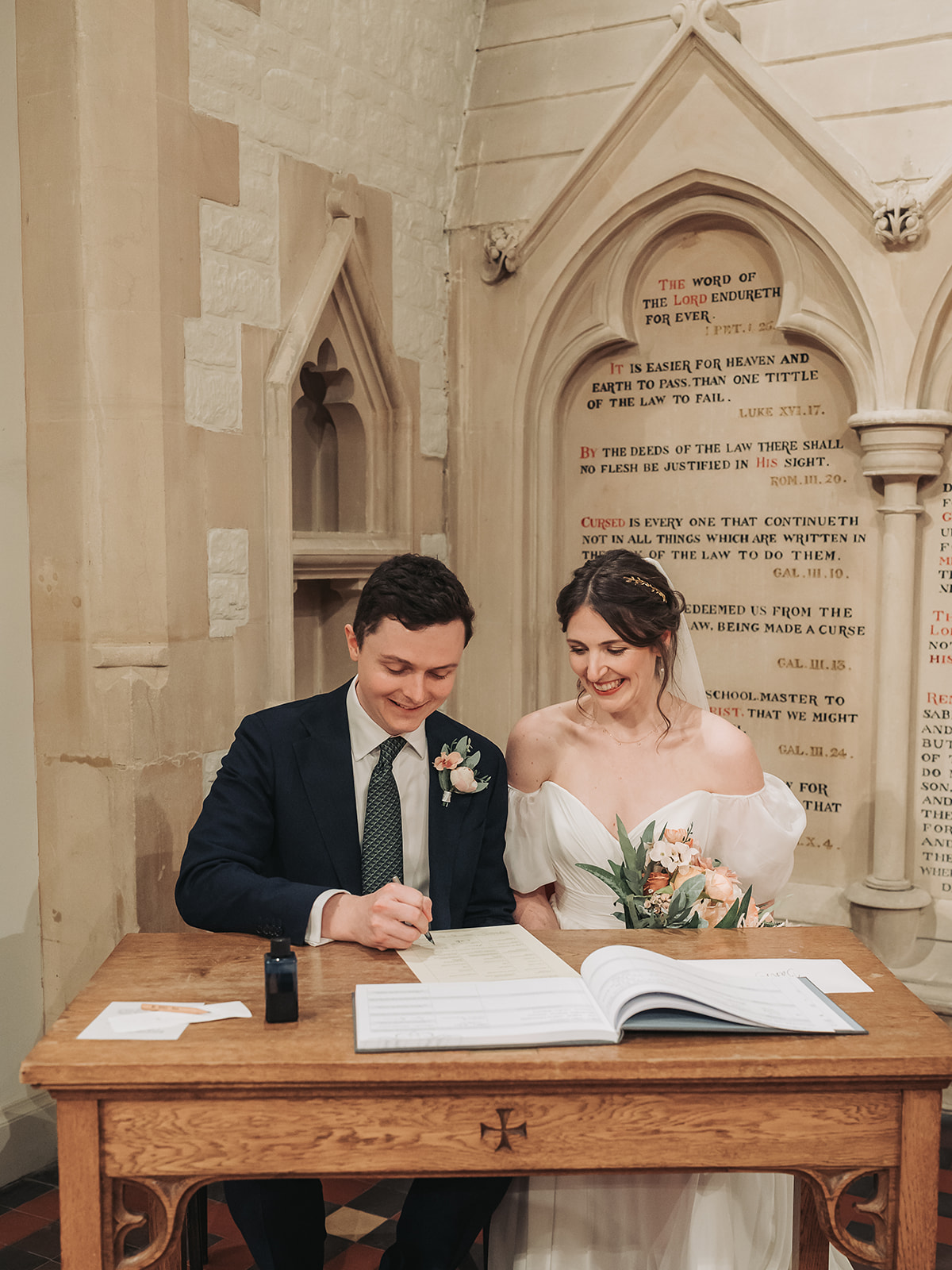 Bride and groom signing register at St Ebbe's