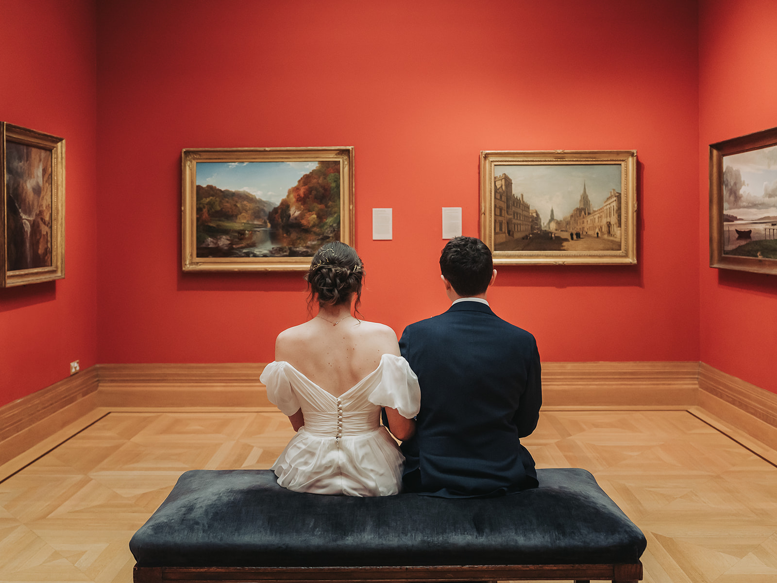 Back of wedding couple in red walled art gallery at Ashmolean museum