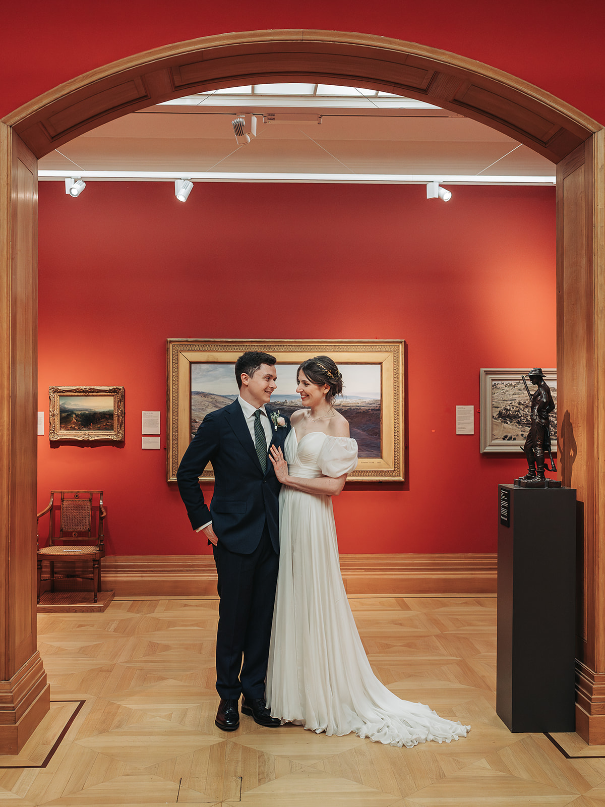 Bride and groom stood looking at eachother in gallery at Ashmolean Museum
