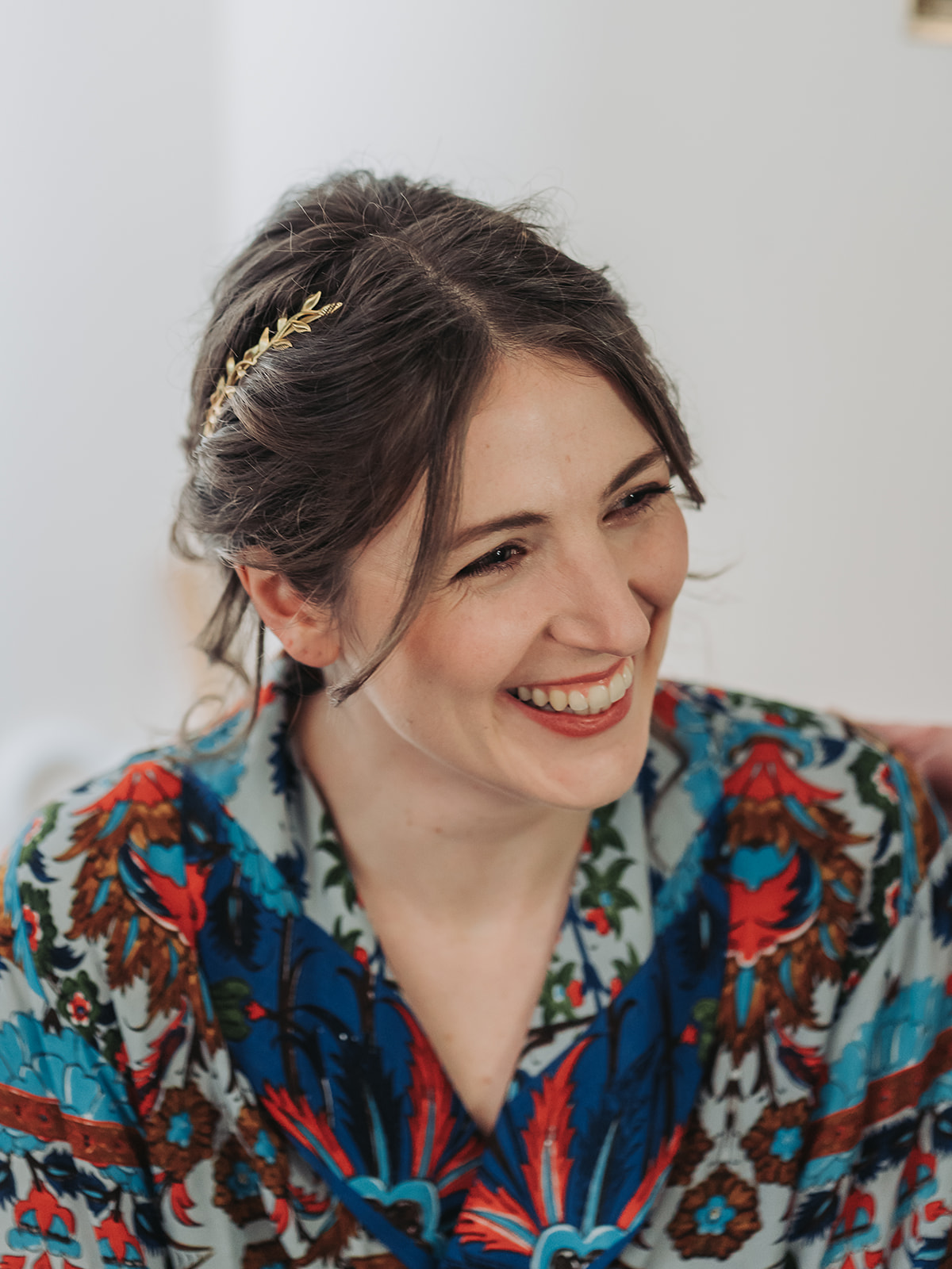 Bride wearing golden hair piece laughing