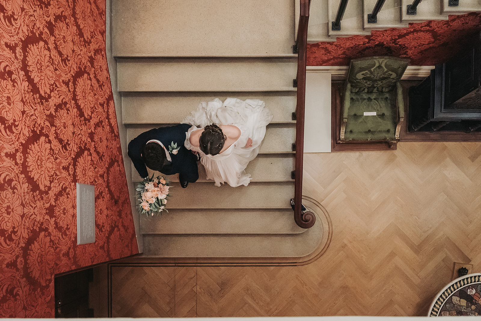 Looking down at wedding couple ascending the stairs at Ashmolean museum