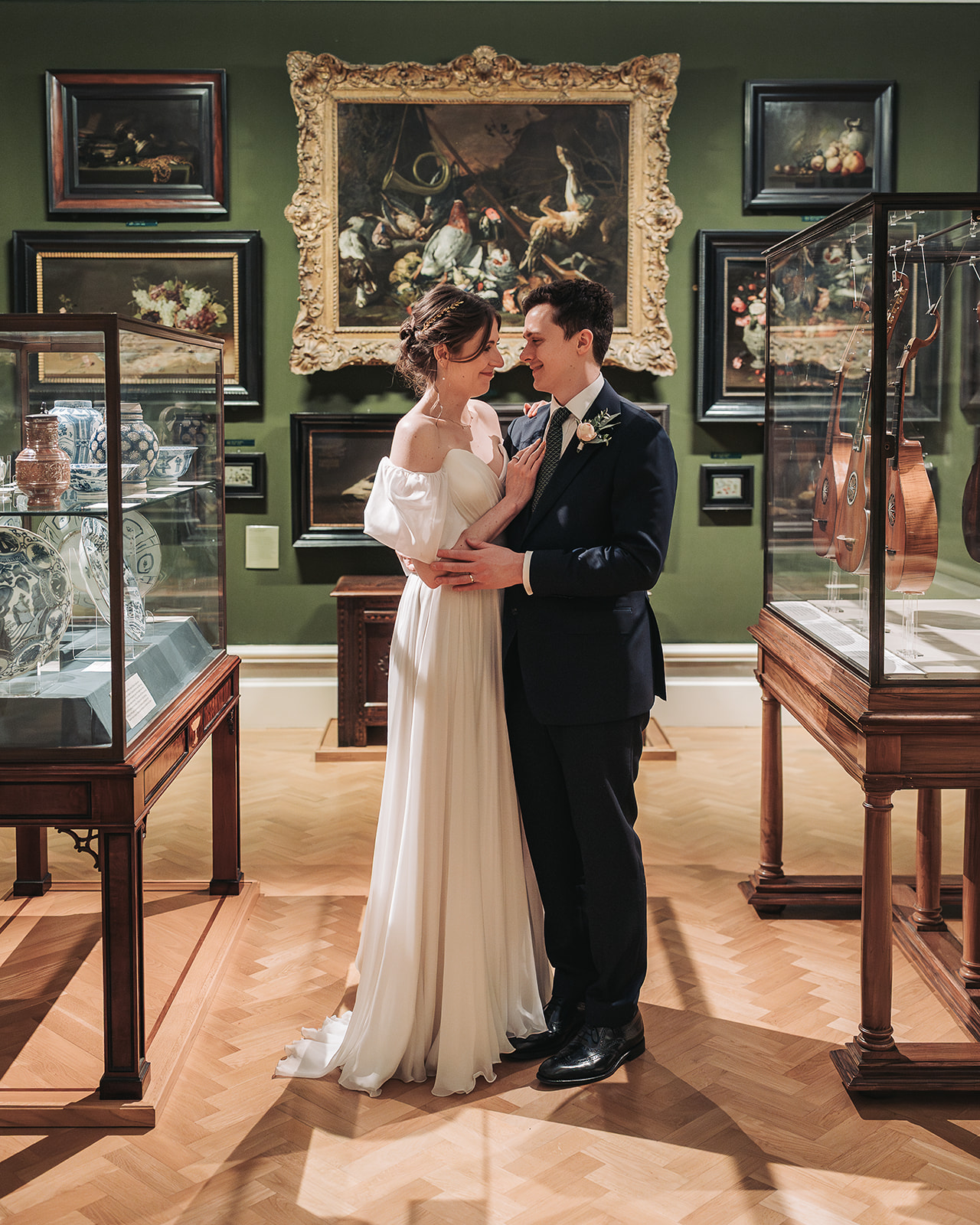 Bride and groom looking at eachother hugging in green gallery in Ashmolean