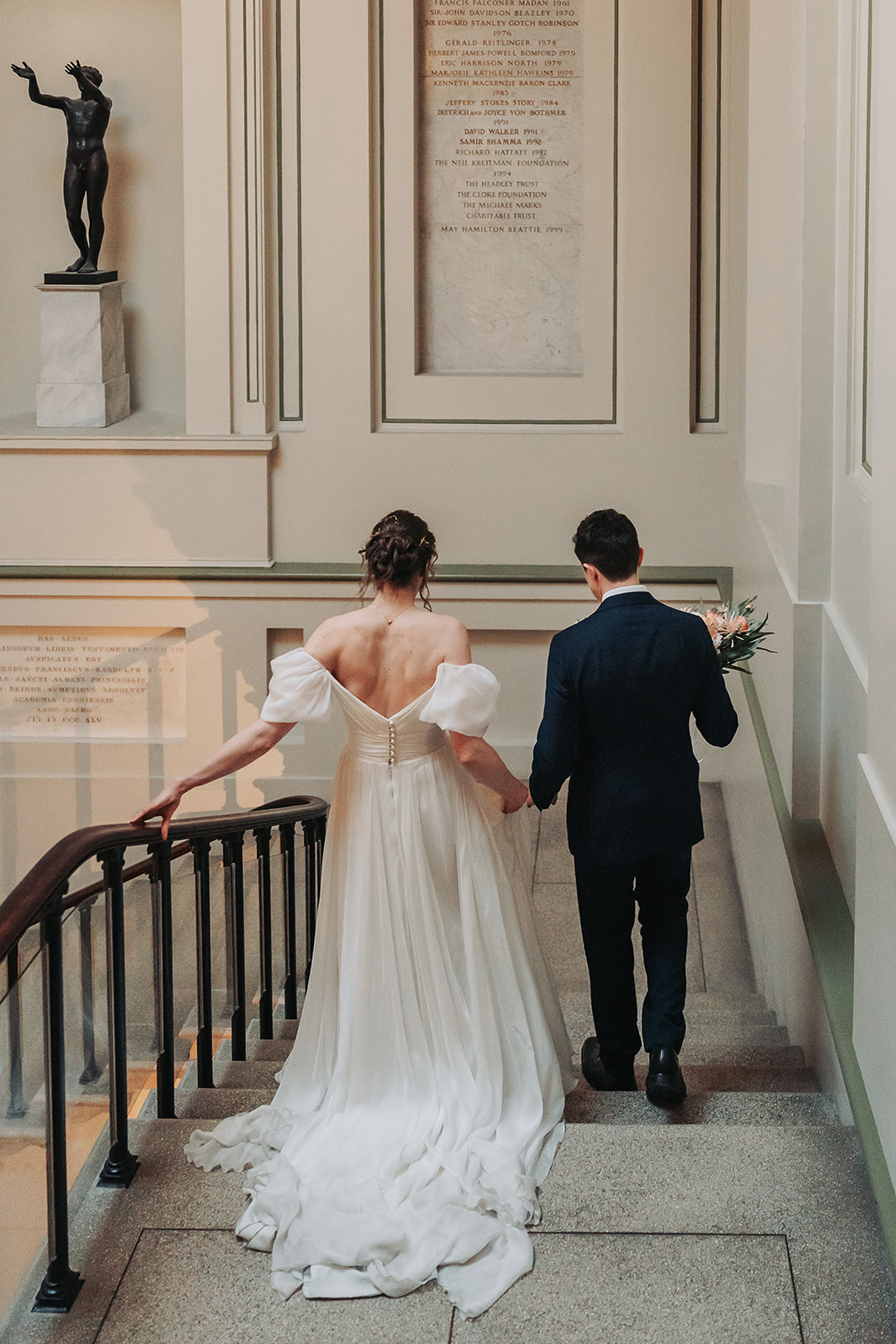 wedding couple walking down the stairs at Ashmolean museum