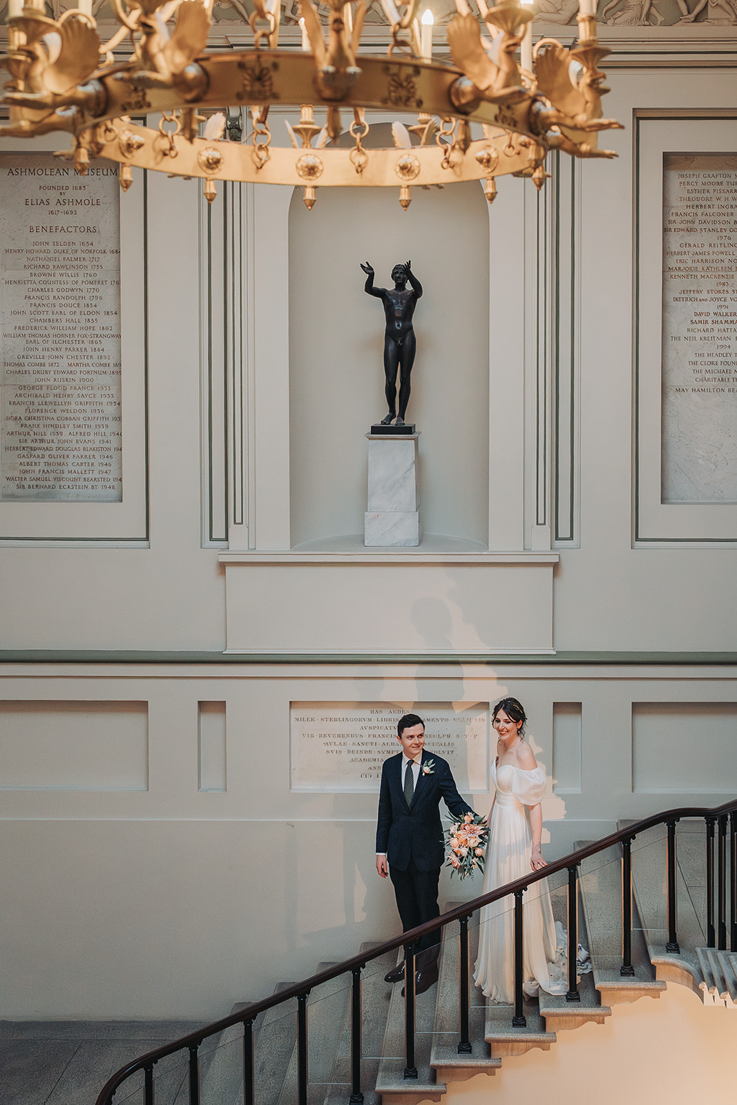 Bride and groom walking down the stairs at ashmolean museum