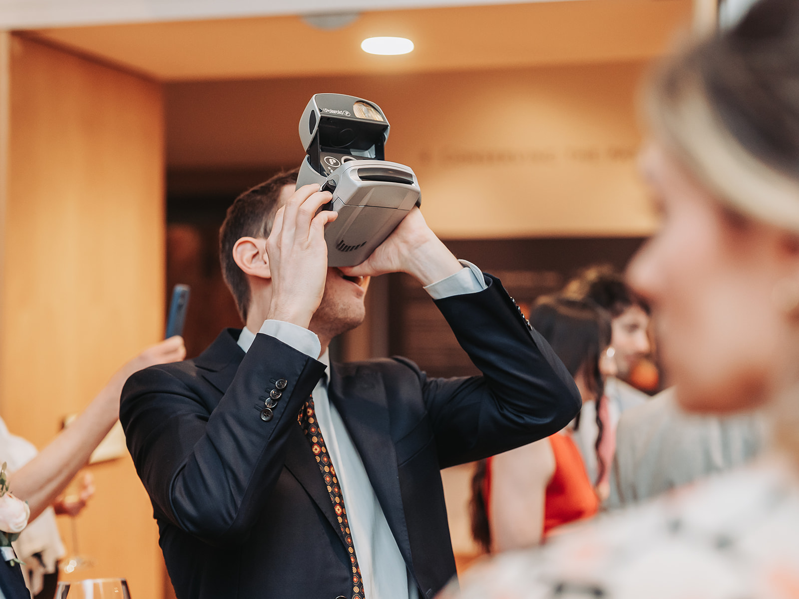 Wedding guest using polaroid camera