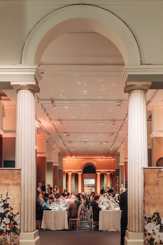 wedding guests sat at tables through archway at Ashmolean Museum
