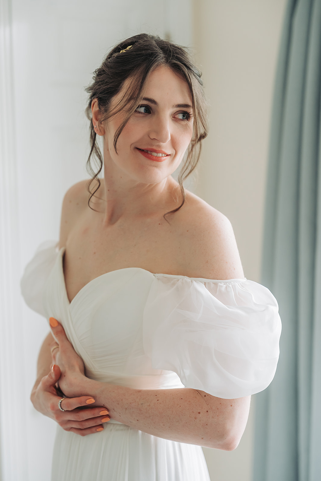 Bride wearing preloved wedding dress glancing over shoulder