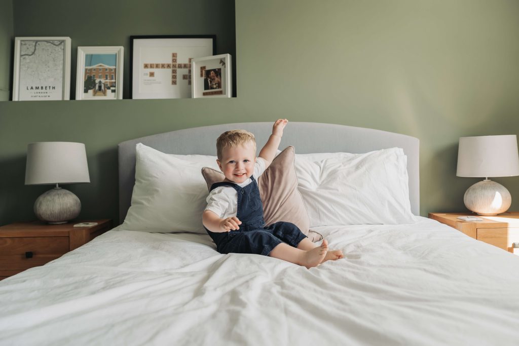 toddler boy landing on bed