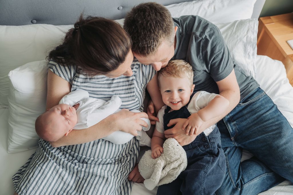 Family photo from above with toddler boy looking up at camera