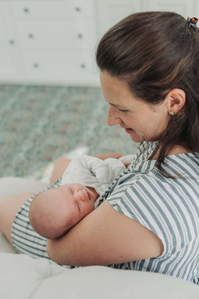 newborn baby in mum's arms asleep during in home photoshoot at home