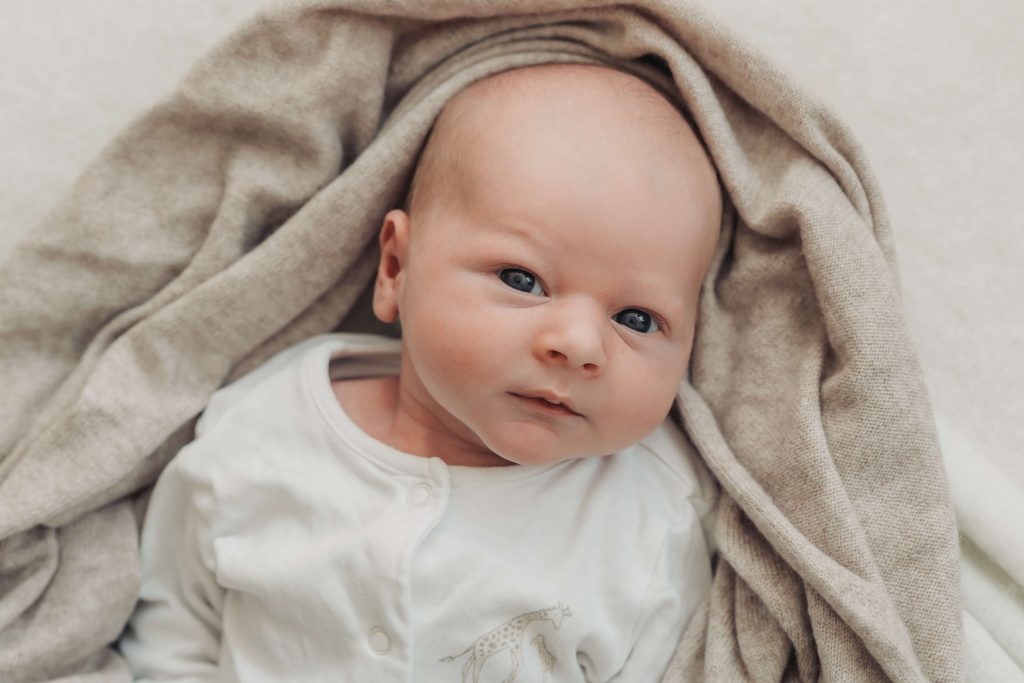 baby looking straight at camera during an in home newborn photoshoot