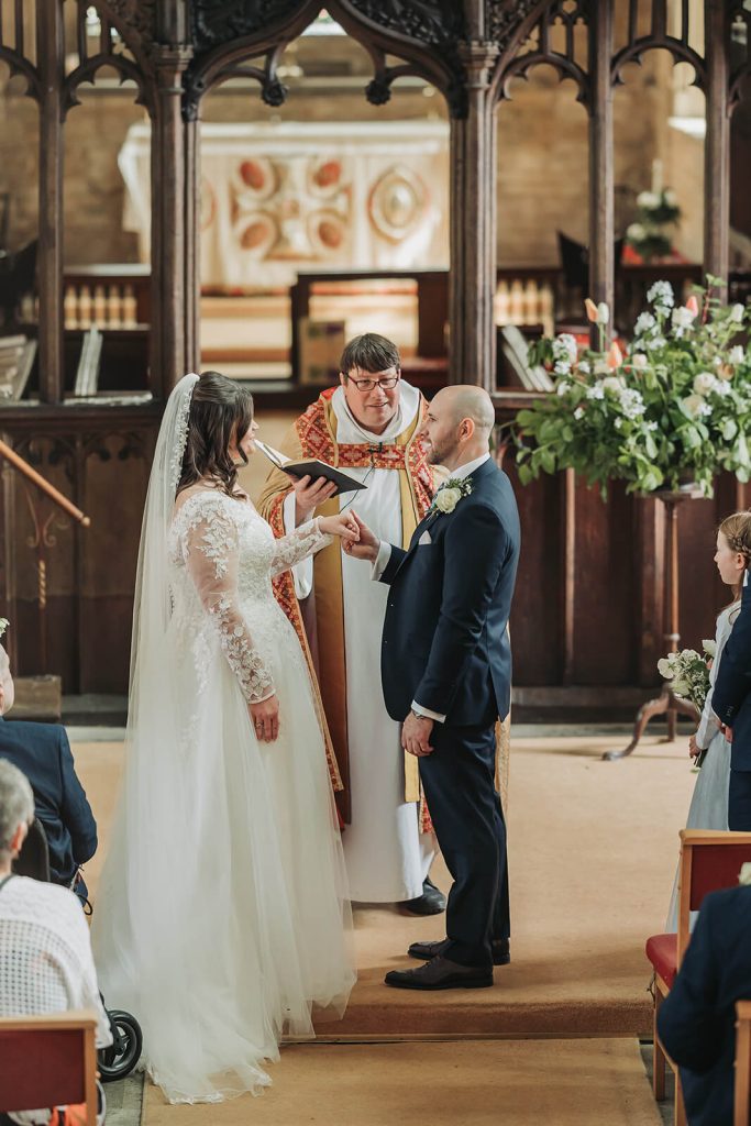 bride and groom sharing vows in church