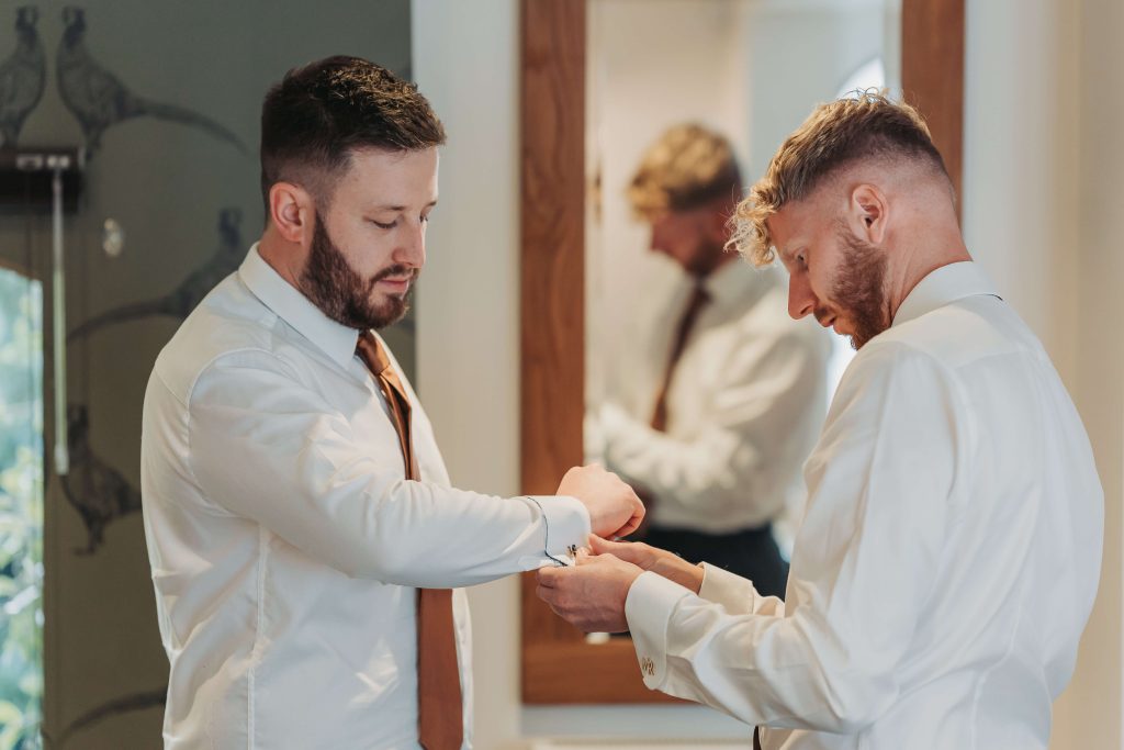 groom and best man doing cufflinks at Mythe Barn wedding venue