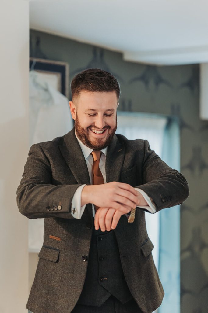groom putting on watch at Mythe Barn wedding venue