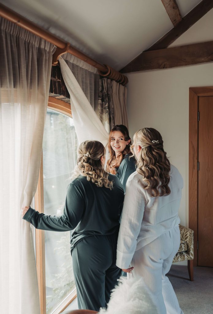 Bridal party looking out of window in pyjamas